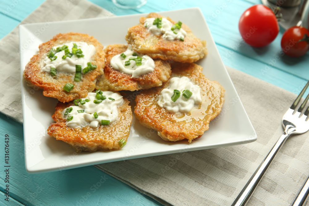 Plate with tasty potato pancakes for Hanukkah on wooden table Plate with tasty potato pancakes for Hanukkah on wooden table