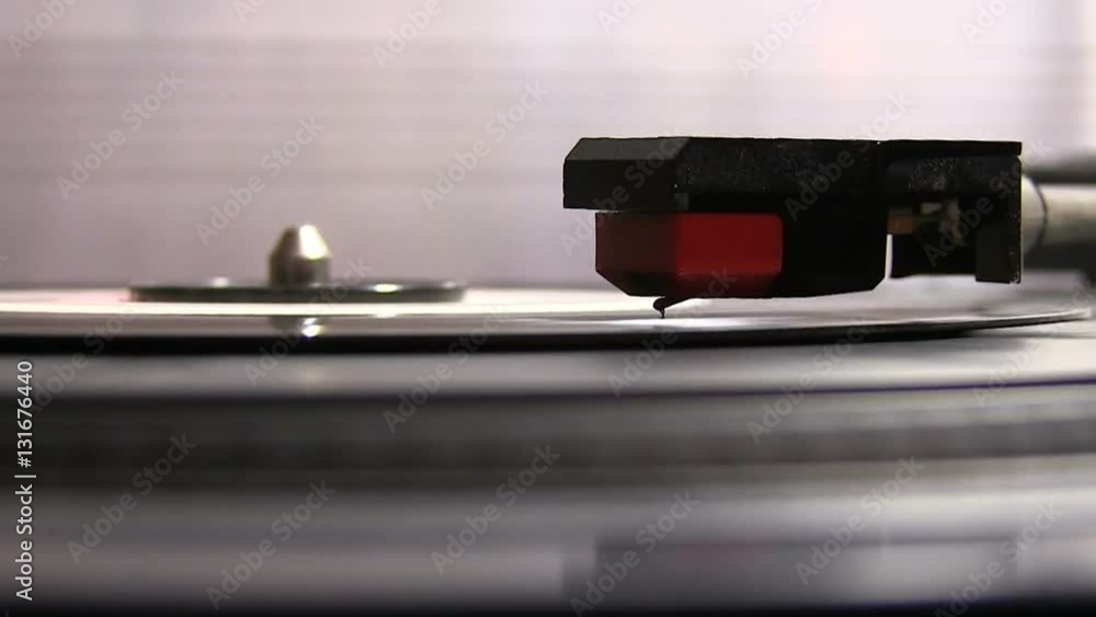 Close ups of an old turntable as the vinyl rotates with a tone arm on it. It's shot from an angel that allows us to see also the needle. Close ups of an old turntable as the vinyl rotates with a tone arm on it. It's shot from an angel that allows us to see also the needle.