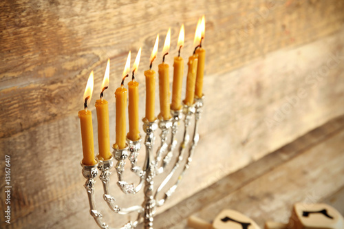 Menorah with candles for Hanukkah on wooden background, close up