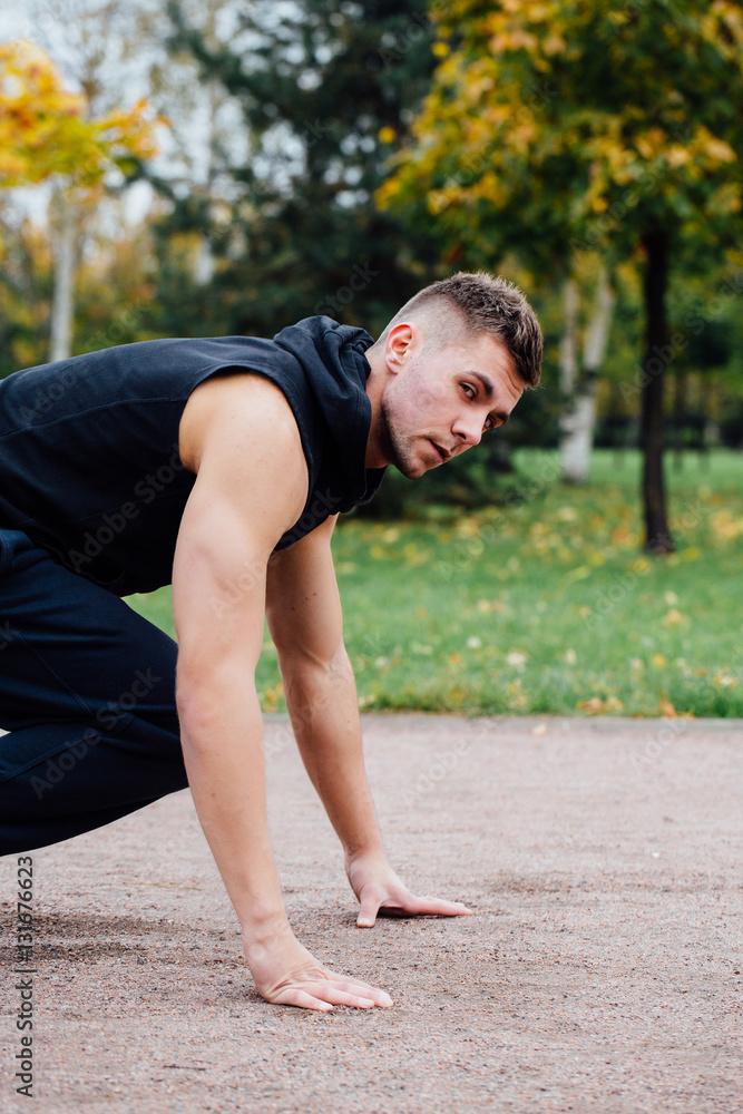 Fitness man training and jogging in fall park. Ready to start. Healthy lifestyle Fitness man training and jogging in fall park. Ready to start. Healthy lifestyle