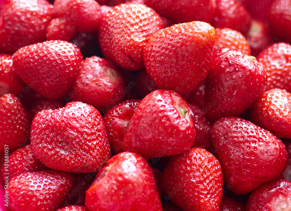 A background of fresh strawberries fruit, close up/Fresh red bright strawberries. Macro, top view A background of fresh strawberries fruit, close up/Fresh red bright strawberries. Macro, top view