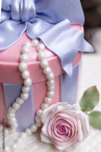 butter cake decorated in sweet round gift box with pastel pink rose fondant and white pearl (selective focus on rose fondant only)