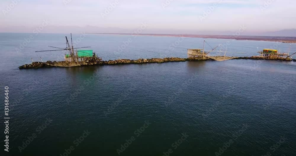Some fishermen houses with huge nets outside situated in the middle of the sea, in Tuscany, Italy Some fishermen houses with huge nets outside situated in the middle of the sea, in Tuscany, Italy