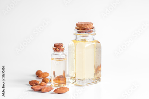 cosmetic almond oil in glass bottle on white background