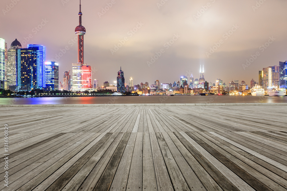 Empty floor with modern skyline and buildings at night in Shanghai