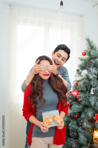 Christmas Asian Couple. A handsome man giving her girlfriend/wif © makistock
