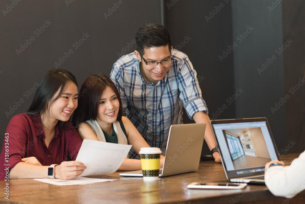 Coworkers meeting in coffee shop work together look at laptop, n Coworkers meeting in coffee shop work together look at laptop, n