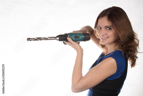Girl with a working tool screwdriver laughing on a white backgro