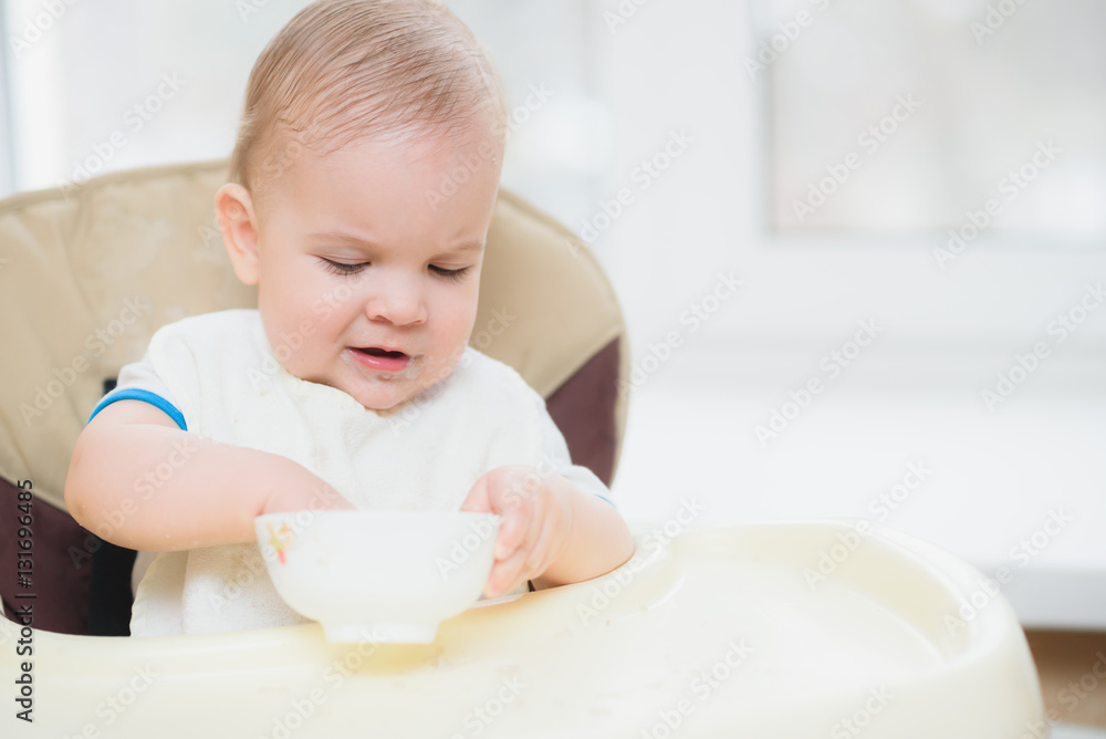 Kid eats porridge hands of the plate Kid eats porridge hands of the plate