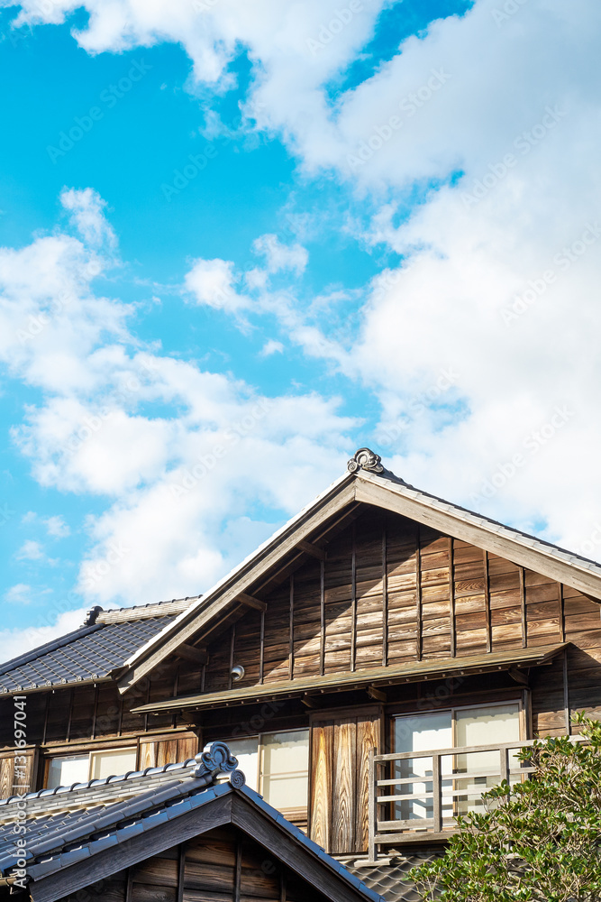 Asia culture concept - japanese traditional historical wooden old house under golden sun and morning blue cloudy sky in Japan
