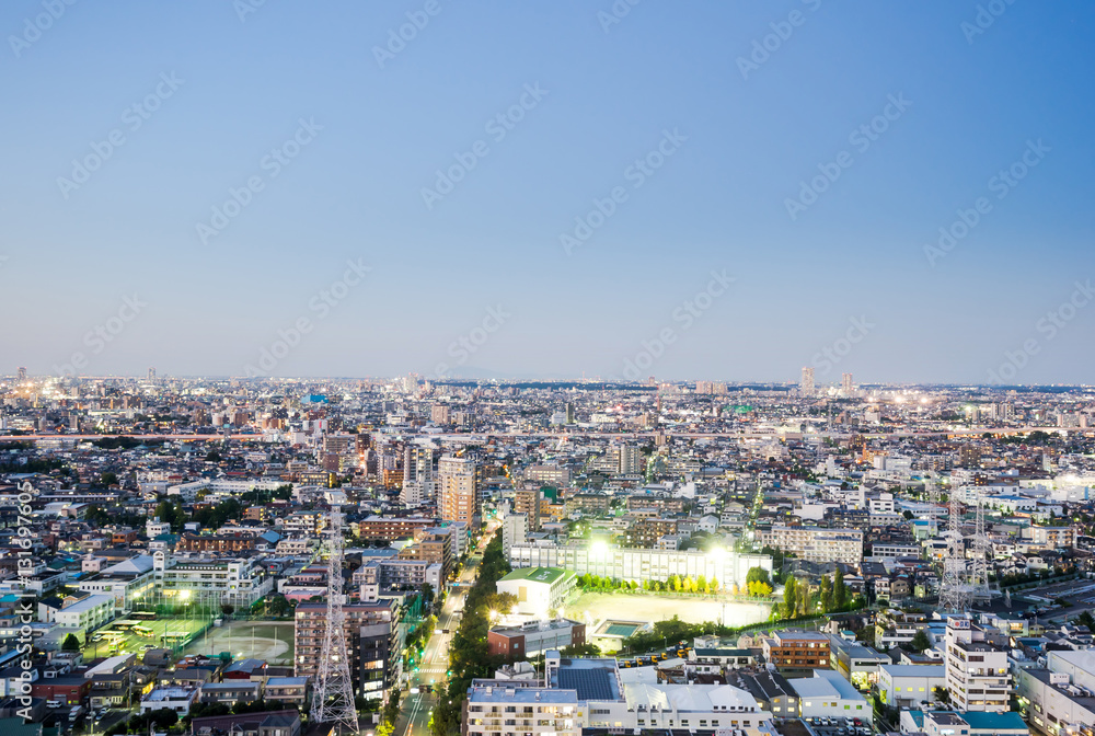 Business and culture concept for real estate and corporate construction - panoramic modern city skyline bird eye aerial night view under dramatic neon glow and beautiful dark blue sky in Tokyo, Japan