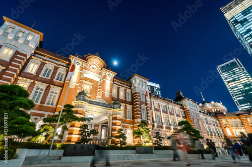Business concept for real estate and corporate construction - panoramic modern city skyline bird eye aerial night view with tokyo station under dramatic glow and beautiful dark blue sky in Tokyo Japan