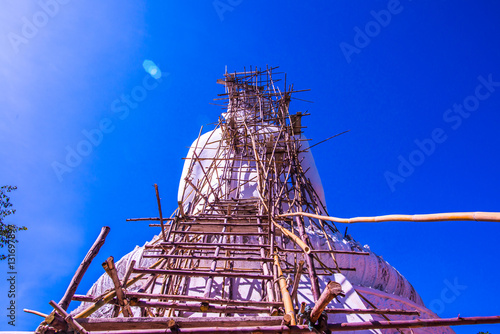 White buddha statue under construction at Phra That Maeyen templ photo