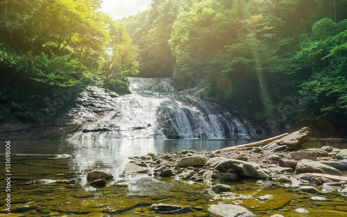 Japan travel concept - beautiful yoro keikoku valley waterfall under dramatic sun glow and morning blue sky in Chiba Prefecture  Japan