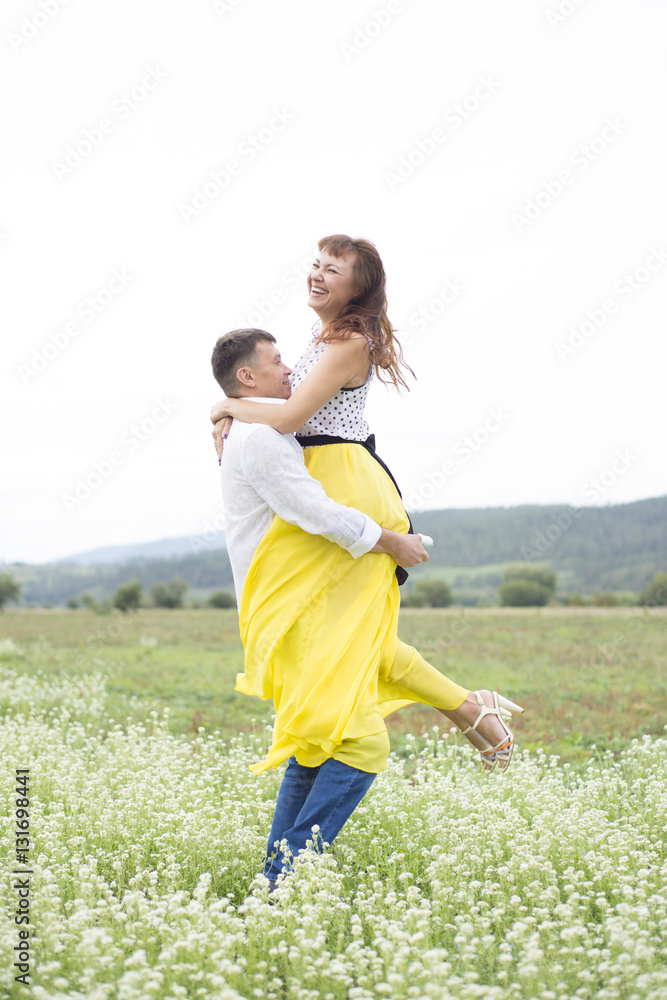 Obraz premium Lovers man and woman walk on the flower field.
