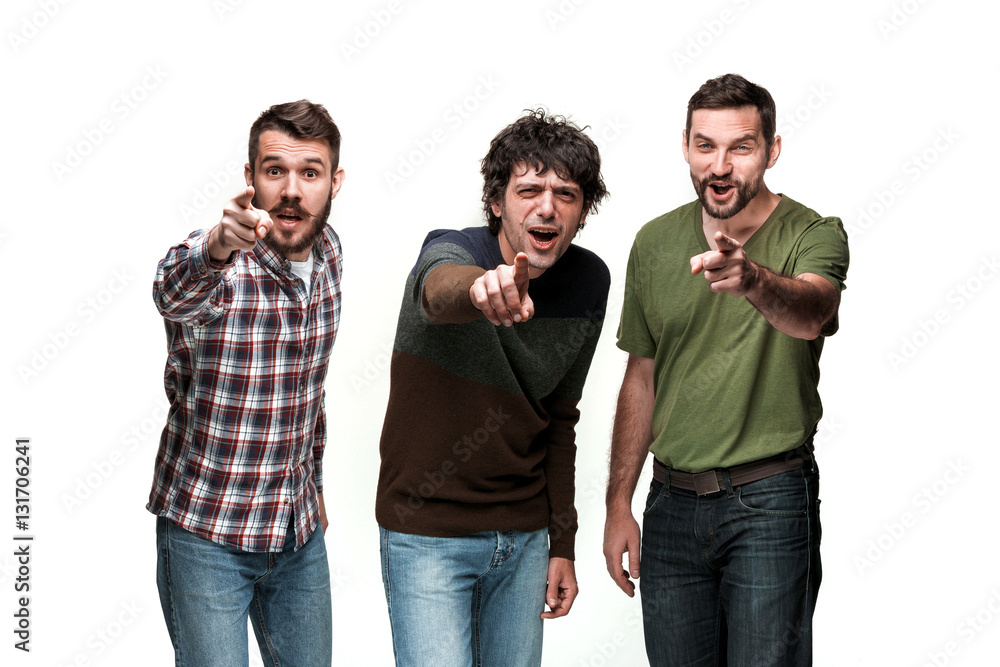 The three men are smiling, looking and pointing at camera The three men are smiling, looking and pointing at camera