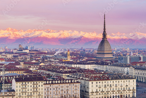 Torino (Turin, Italy): cityscape at sunrise with details of the Mole Antonelliana towering over the city. Scenic colorful light on the snowcapped Alps in the background. © fabio lamanna