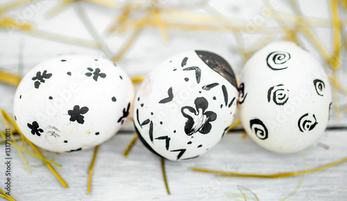 Easter composition with white eggs black pattern