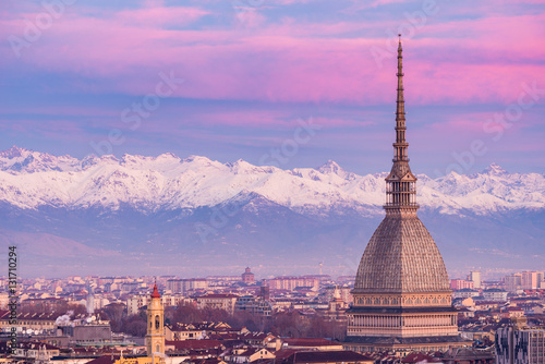 Torino (Turin, Italy): cityscape at sunrise with details of the Mole Antonelliana towering over the city. Scenic colorful light on the snowcapped Alps in the background. © fabio lamanna