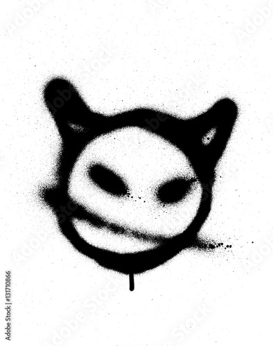 graffiti sprayed devil emoticon in black on white