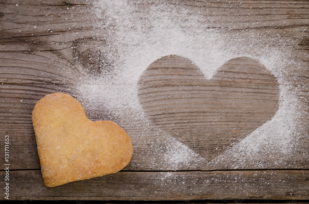 Obraz premium mark in shape of heart with powdered sugar and cookie