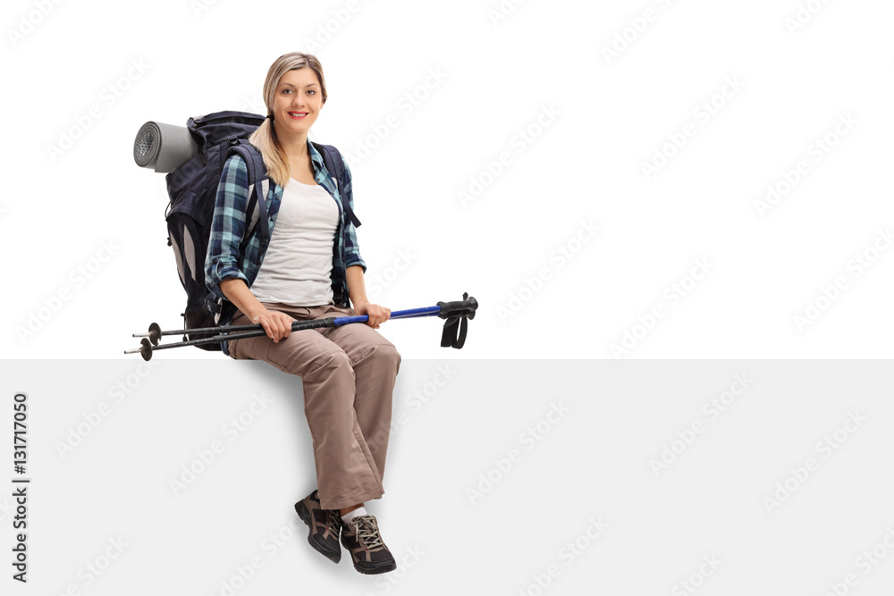 Happy female hiker sitting on a panel Happy female hiker sitting on a panel