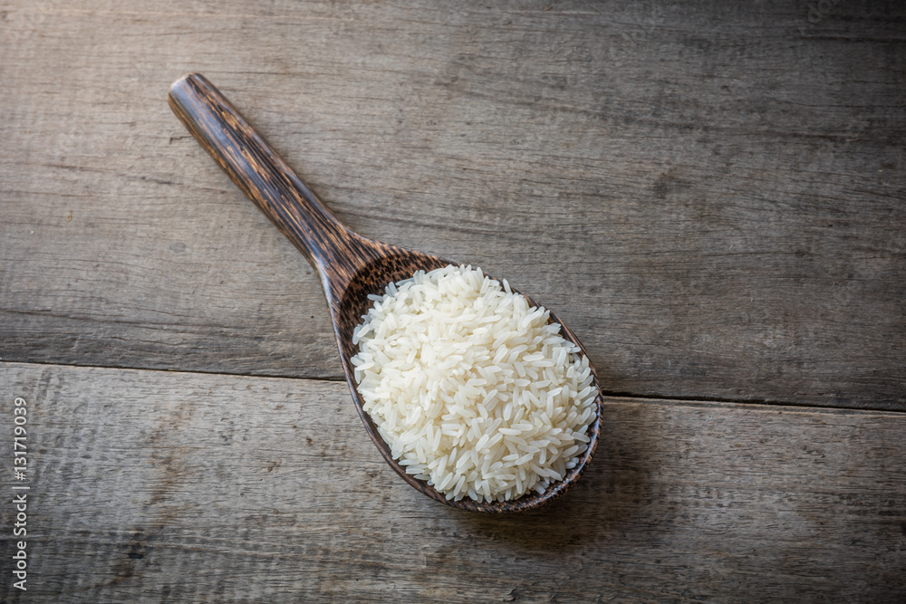 Rice on Wooden Spoons on wooden background Rice on Wooden Spoons on wooden background