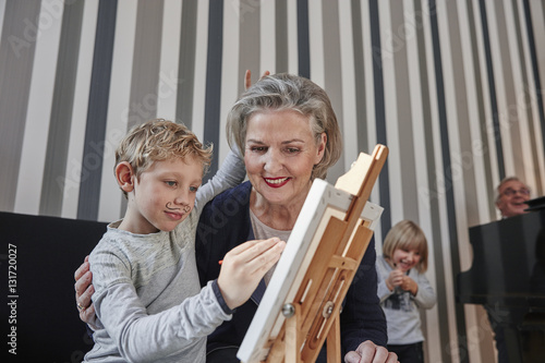 Grandmother and grandson with Dali moustache at easel photo