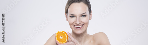 Smiling woman holding an orange