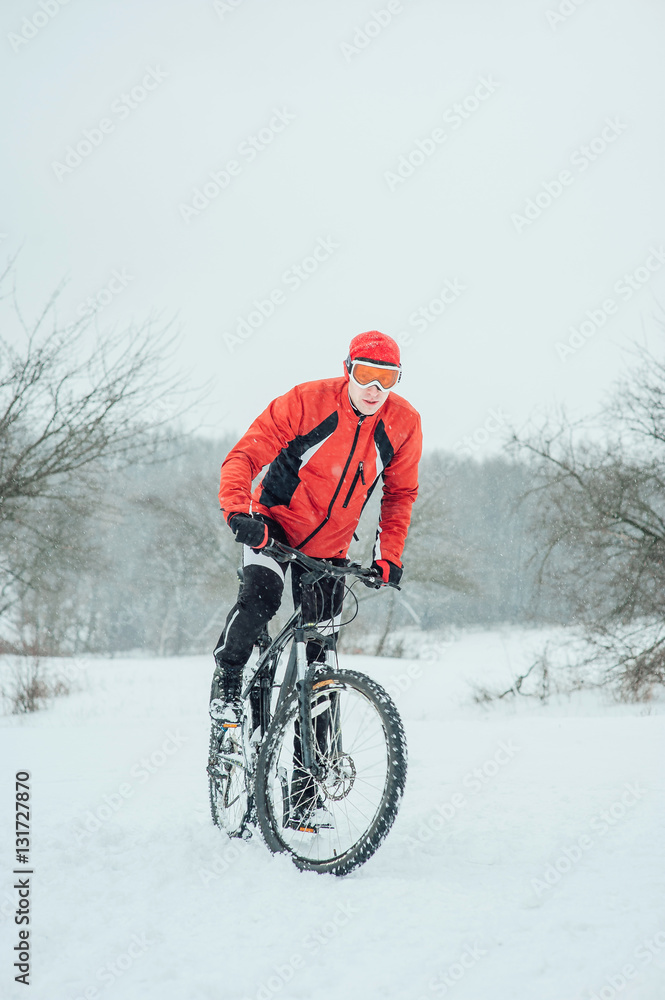 Extreme cyclist rides in the winter snowy forest Extreme cyclist rides in the winter snowy forest