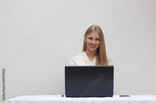 Happy businesswoman working on her laptop in the office
