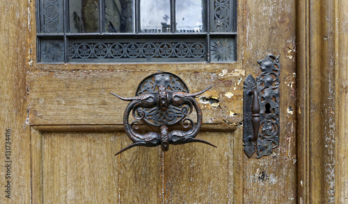 Antiquely designed door knob over a wooden door photo