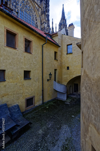 View of a yellow textured building with a narrow brick street in between