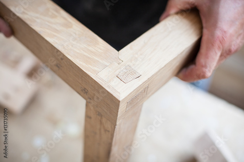 Detail of a furniture maker holding an example of his intricate