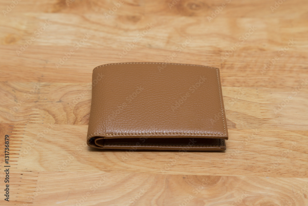Brown leather wallet isolated on wooden table Brown leather wallet isolated on wooden table