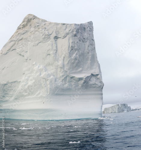 Arctic Icebergs Greenland in the arctic sea. You can easily see that iceberg is over the water surface, and below the water surface. Sometimes unbelievable that 90% of an iceberg is under water photo