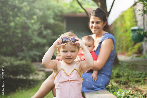 Close up portrait of a young daughter wearing her mums sunglasse