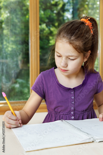 Young girl writes in her Science Fair eperiment notebook