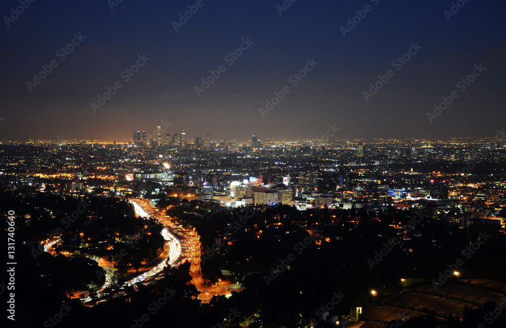 Los Angeles Skyline of Downtown with skyscrapers, urban buildings and traffic on Interstate 101 at night