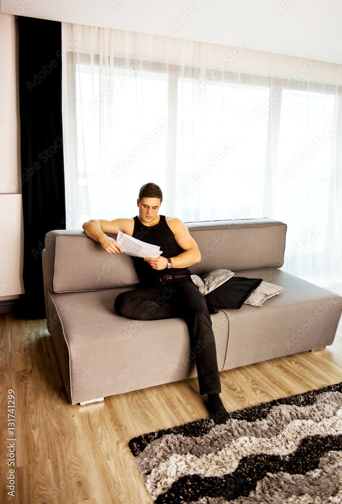Cheerful young man sitting on sofa. Cheerful young man sitting on sofa.