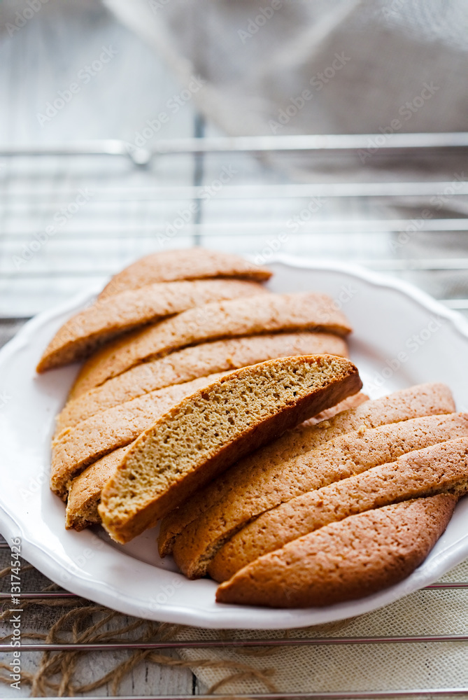 Gingerbread biscotti on a white plate. Wire rack and linen on table Gingerbread biscotti on a white plate. Wire rack and linen on table