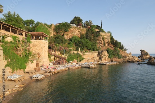 Fototapeta Naklejka Na Ścianę i Meble -  Mermerli Beach and Restaurant with the City Walls in Antalyas Oldtown Kaleici, Turkey