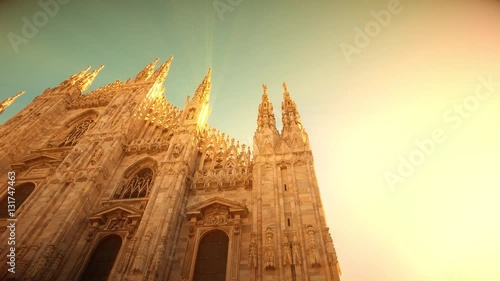 Sunset view of Milan Cathedral (Duomo di Milano) and piazza del Duomo in Milan (Italy) with sunlight and rays from the sun and magic atmosphere photo