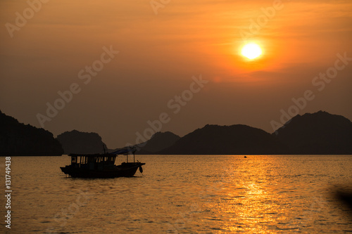Asian fishing boats at sunset on a background of mountains. © photominus21