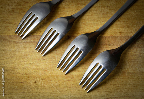 four forks obliquely on wood