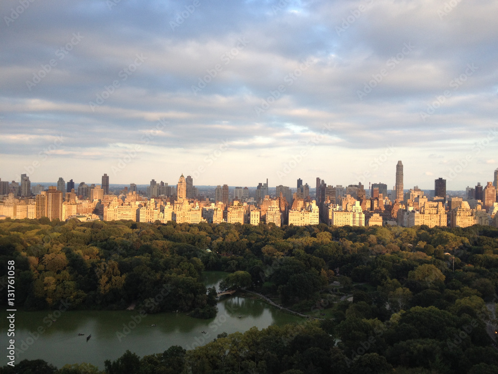 Warm light at sunset on the buildings of the Upper East Side and Central Park.The Lake and the Ramble of Central Park in Manhattan, New York City.