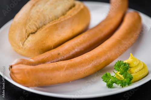 Some Sausages (Frankfurter) on a dark slate slab