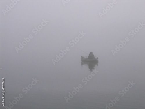 Lone fisherman on the river in a fog