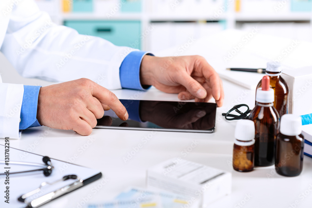 Doctor's hands working on a digital tablet at his Office