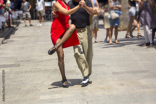 Street dancers performing tango in the street among the people